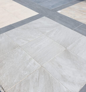 A patio space using light grey, dark grey and cream porcelain slabs.