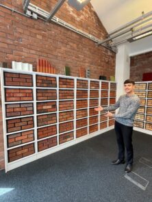 Salesperson pointing towards a brick display.