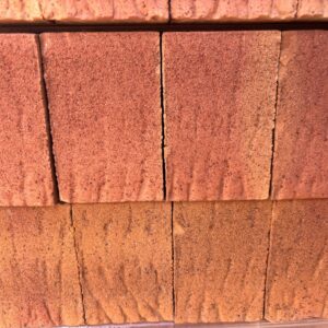 A photograph of the ends of red bricks, demonstrating a rolled finish.