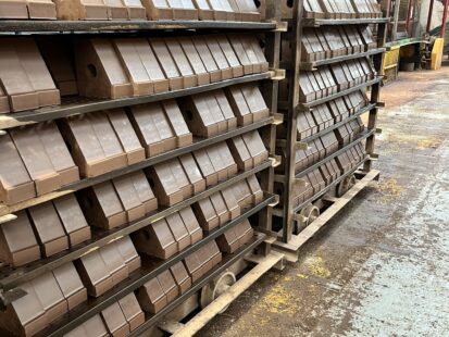 Shelves containing wet clay formed into special brick shapes.