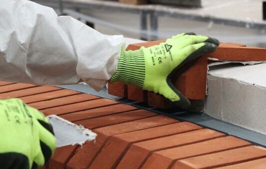 Someone piecing together a brick slip arch.