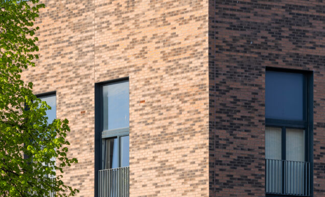 Close up of a three-storey residential building in Pennywell Regeneration, completed using Heritage Dragwire and Village Harvest Multi facing bricks.