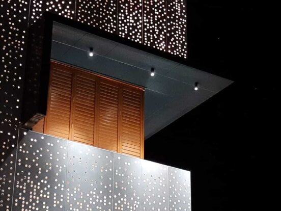Light display within perforated metal cladding