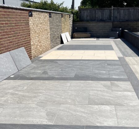Several different neutral tones of porcelain paving laid in square patterns with contrasting borders.