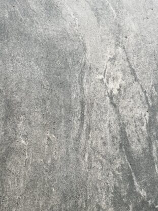 A close up of a grey, marble-effect porcelain paving slab.