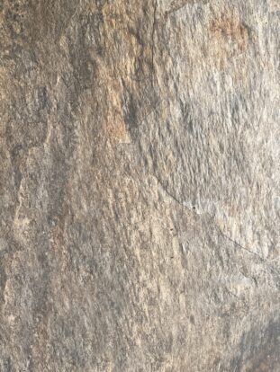 A close up of a grey and copper-coloured porcelain paving slab.