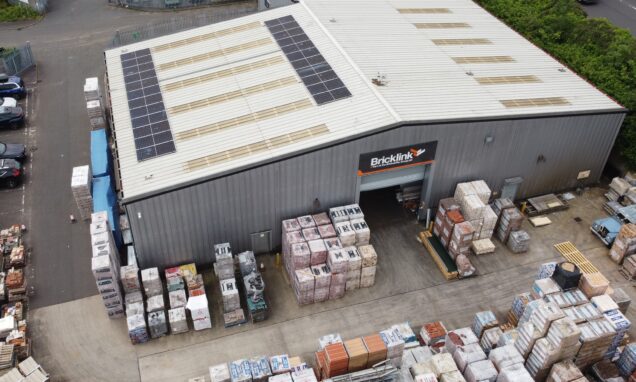 An aerial view of Bricklink's depot, with lots of bricks outside and solar panels on the roof.