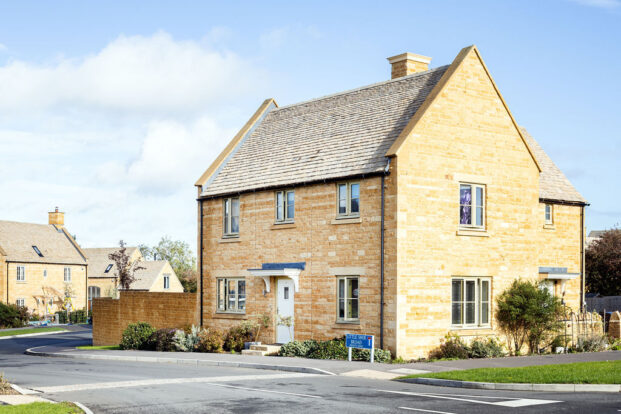 A stone house in a housing estate on a sunny day.