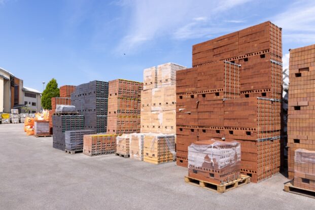 A row of stacked red, buff and black bricks.