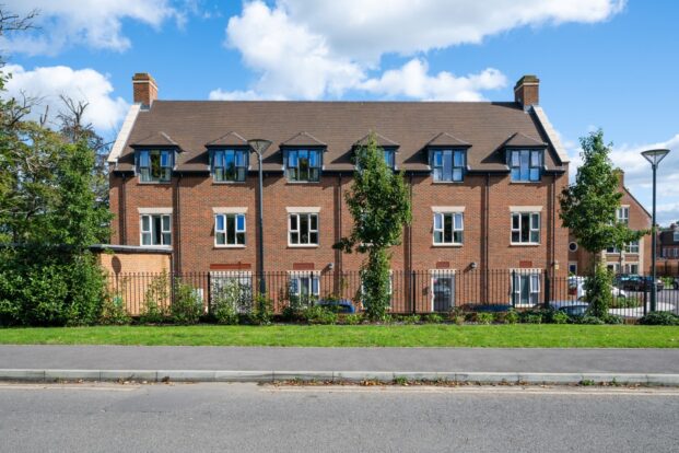 A photograph of a new-build red-brick care home with stone headers above the windows.