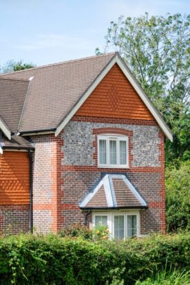 A house with red slate, flint block and brickwork facade.