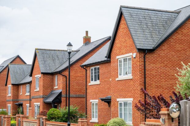 Row of red-brick houses with small front gardens.