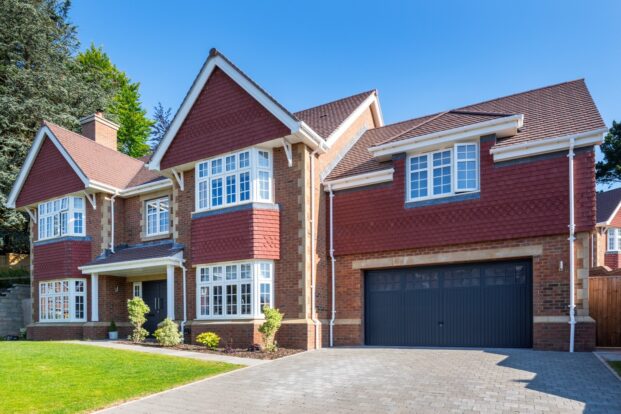 Large red-brick, detached house with garage.