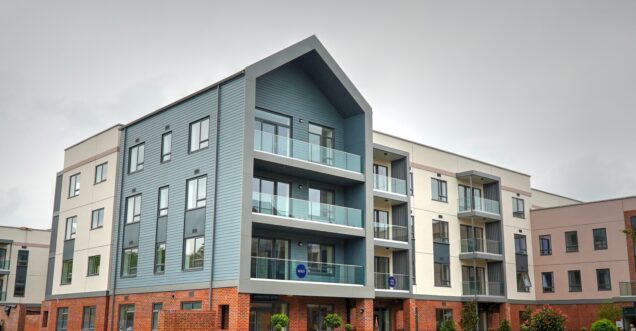 A modern apartment block with a colourful blue, cream and pink facade.