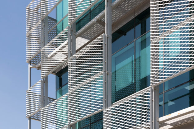 White expanded mesh cladding next to turquoise glass