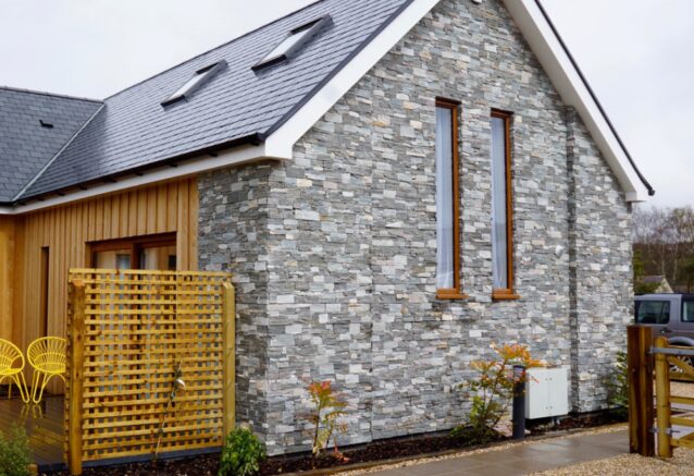 A modern house with a grey stone facade.