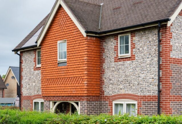 A traditional house featuring red tiles and flint panels.