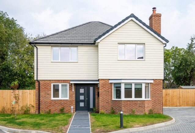 A dethatched, two-storey home with a red brick ground floor and a white Hardie Plank first floor.