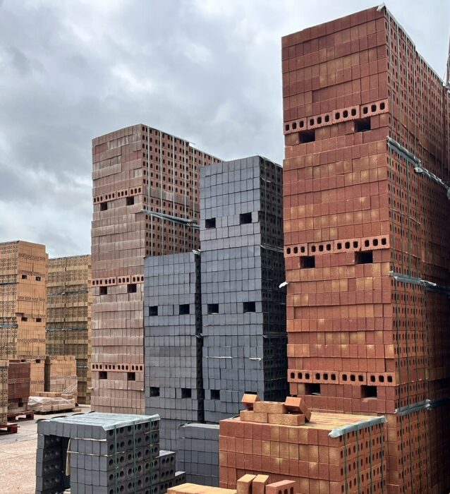 Stacks of brick palettes with red, black and buff bricks.