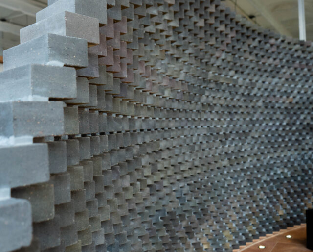 A decorative curved wall made from dark grey bricks.