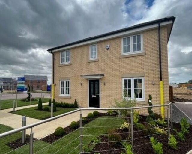 A buff-brick house with a neat front garden.