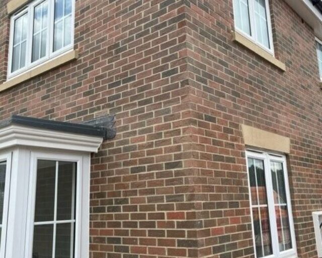 The corner or a red-brick house with four windows.