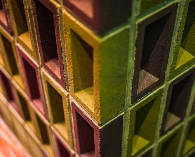 A wall built from pink and yellow bricks with their frogs facing outwards.