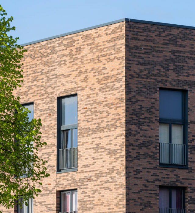 Close up of a three-storey residential building in Pennywell Regeneration, completed using Heritage Dragwire and Village Harvest Multi facing bricks.