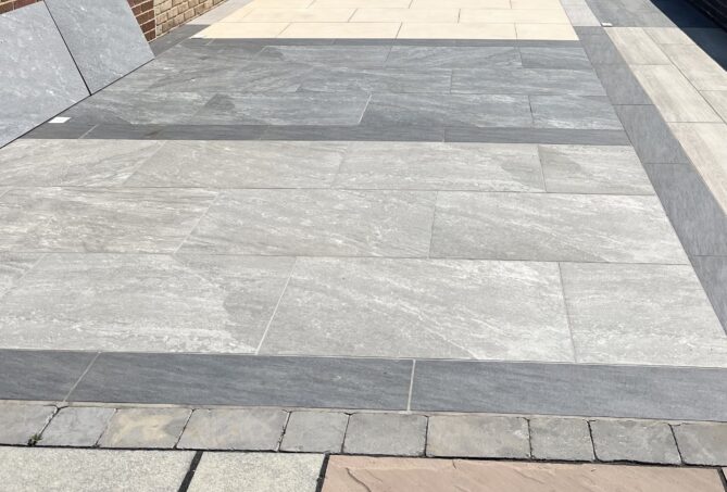 A patio display outdoors on a sunny day featuring an array of porcelain slabs.