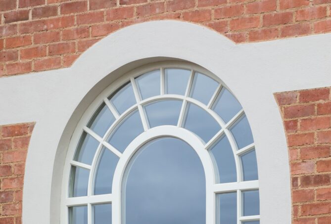 A picture of a window with a curved stone header made possible by a lintel.