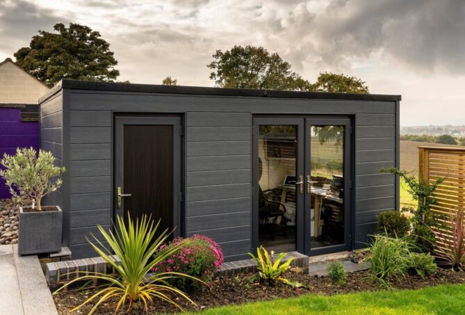 A garden room with anthracite grey panel walls, pictured in a domestic garden.