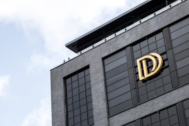 Gold sign near the top of the Dakota Hotel black brick facade